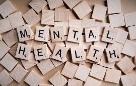 The word "mental health" spelled out in Scrabble pieces.