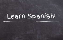 "Learn Spanish" written on chalkboard.