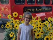 Child in front of trolley and sunflowers