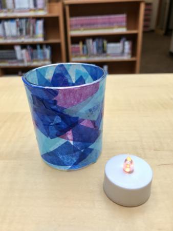 Votive candle holder decorated with purple and blue tissue paper