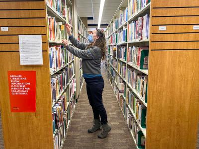 Woman browsing library book shelves