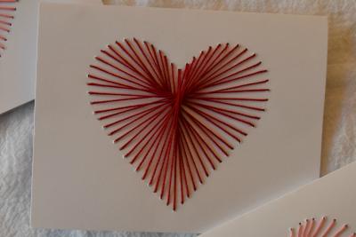 Card with a heart made out of embroidery thread.