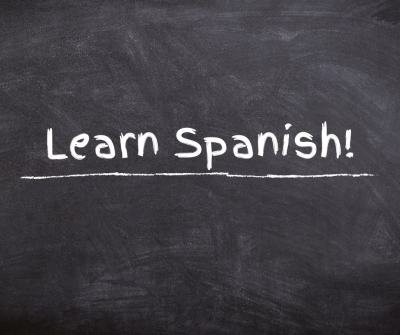 "Learn Spanish" written on chalkboard.