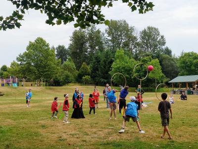 Kids playing Quidditch in the park.
